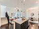 Open kitchen showcasing dark wood floors, granite island with seating, and open access to living spaces at 10479 E 25Th Dr, Aurora, CO 80010