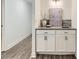 Dry bar with white cabinets and granite countertops located next to a doorway and gray laminate flooring at 10479 E 25Th Dr, Aurora, CO 80010