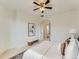 Bright main bedroom with neutral tones, ceiling fan, and view to an adjacent bathroom at 10479 E 25Th Dr, Aurora, CO 80010