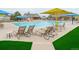 Relaxing pool area featuring lounge chairs, tables, umbrellas, and lush green turf surrounding the pool deck at 23406 E 5Th Pl # 203, Aurora, CO 80018