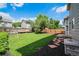 Fenced backyard with a fire pit, grass area, and treehouse in a tranquil setting at 5573 S Taft St, Littleton, CO 80127