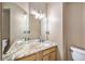 Bathroom featuring a dual sink vanity with granite countertop and decorative lighting at 5573 S Taft St, Littleton, CO 80127
