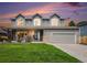 Charming two-story home featuring stone accents, three dormer windows, and a well-manicured lawn at 5573 S Taft St, Littleton, CO 80127