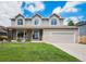 Charming two-story home featuring stone accents, three dormer windows, and a well-manicured lawn at 5573 S Taft St, Littleton, CO 80127