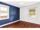 Charming bedroom features a striking blue accent wall and beautiful hardwood floors at 4421 Raleigh St, Denver, CO 80212