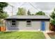 Charming single-story structure featuring gray siding and a vibrant blue door, nestled in a well-maintained grassy yard at 4421 Raleigh St, Denver, CO 80212