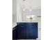 Stylish kitchen island with blue cabinets, white countertops, and modern pendant lights at 4421 Raleigh St, Denver, CO 80212