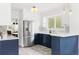 Modern kitchen with stainless steel appliances, white cabinets, and blue lower cabinets at 4421 Raleigh St, Denver, CO 80212