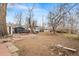 Expansive backyard with mature trees, brick patio, shed, and fire pit at 75 Vrain St, Denver, CO 80219