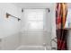 Bathroom with white tiled walls, a window with sheer curtains, and chrome fixtures at 75 Vrain St, Denver, CO 80219