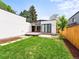 Modern home featuring a backyard with a deck, manicured lawn, stone path, and new fence at 2025 Fenton St, Edgewater, CO 80214