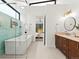 Bright bathroom with a soaking tub, glass shower, and a view into the cozy bedroom at 2025 Fenton St, Edgewater, CO 80214