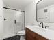 Modern bathroom featuring black fixtures, a wood vanity, white countertops, and a sliding glass door shower at 2025 Fenton St, Edgewater, CO 80214