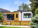 Modern home featuring unique architecture, beautiful wood siding and black trim, and a well-maintained lawn with wood fencing at 2025 Fenton St, Edgewater, CO 80214