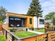 Contemporary home featuring wood and black siding, a well-manicured lawn and modern landscaping, and a lovely entryway at 2025 Fenton St, Edgewater, CO 80214