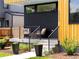 Charming front porch with modern railings, stylish outdoor seating, and manicured landscaping, leading to the front entrance at 2025 Fenton St, Edgewater, CO 80214