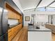 Bright and modern kitchen with a large island, wooden cabinets, black countertops, and a view into the open-concept living space at 2025 Fenton St, Edgewater, CO 80214