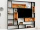 Modern shelving unit featuring a black frame and wood insets around the TV in living room at 2025 Fenton St, Edgewater, CO 80214