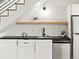 Under-stairs wet bar features a sink, beverage refrigerator, and modern white cabinetry at 2025 Fenton St, Edgewater, CO 80214