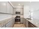 Well-lit kitchen with granite countertops, stainless steel appliances, and sleek gray cabinetry at 3831 E 141St Ave, Thornton, CO 80602