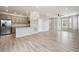 Bright and airy living area open to the kitchen, featuring modern light fixtures and hardwood floors at 3831 E 141St Ave, Thornton, CO 80602