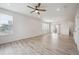 Bright living room featuring light wood flooring, large windows, and a modern ceiling fan at 3831 E 141St Ave, Thornton, CO 80602