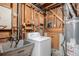 Unfinished basement laundry area with a washing machine, utility sink, and exposed wooden beams at 1010 Kennedy Dr, Westminster, CO 80234