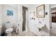 Cozy bathroom featuring a tiled shower, neutral-toned floor, and a classic square mirror over the sink at 1010 Kennedy Dr, Westminster, CO 80234