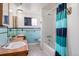 Bathroom featuring double vanity, shower/tub combo, and aqua tile at 1010 Kennedy Dr, Westminster, CO 80234