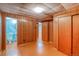 Expansive basement area with wood paneled walls, featuring access to both a bathroom and another finished room at 1669 S Kearney St, Denver, CO 80224