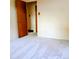 View of a bedroom with light gray carpet, base trim, and simple doors enhancing the room's clean aesthetic at 1669 S Kearney St, Denver, CO 80224