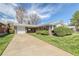 Charming brick ranch home with a well-manicured front yard and a long driveway to an attached garage at 1669 S Kearney St, Denver, CO 80224