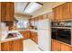 Retro-styled kitchen featuring wooden cabinets, vintage appliances, and a view into the adjacent dining area at 1669 S Kearney St, Denver, CO 80224