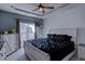 Cozy main bedroom with a tray ceiling, fan, and large window for natural light at 6722 S Winnipeg Cir # 102, Aurora, CO 80016