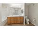 Bright bathroom features a double sink vanity, framed mirror, and tub with white tile surround at 7440 S Blackhawk St # 2-203, Englewood, CO 80112