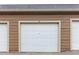 Garage parking with white door at 7440 S Blackhawk St # 2-203, Englewood, CO 80112