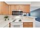 Efficient kitchen design with updated appliances, neutral countertops and wooden cabinets at 12053 E Harvard Ave # 107, Aurora, CO 80014