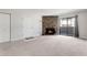Open living room with neutral carpet, a stone fireplace, closet, and sliding glass doors at 12053 E Harvard Ave # 107, Aurora, CO 80014