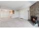 Spacious living room features neutral carpet, a stone fireplace, and a kitchen view at 12053 E Harvard Ave # 107, Aurora, CO 80014