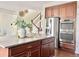 Kitchen view showcasing a large island, stainless appliances, and a staircase to the upper level at 12627 Fisher Dr, Englewood, CO 80112