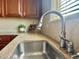 Stainless kitchen sink faucet and granite counters compliment the window light at 12627 Fisher Dr, Englewood, CO 80112