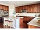 Kitchen featuring a large island with bar seating, stainless appliances, and dark wood cabinetry at 12627 Fisher Dr, Englewood, CO 80112