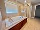 Bright bathroom showcasing a soaking tub with tile surround and a glass-enclosed shower at 12627 Fisher Dr, Englewood, CO 80112