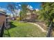 Beautiful backyard features a lush lawn, stone landscaping, mature trees, and privacy fencing on a sunny day at 12821 W 60Th Ave, Arvada, CO 80004