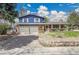 Charming two-story home boasts a blue exterior, brick accents, and a convenient two-car garage at 12821 W 60Th Ave, Arvada, CO 80004