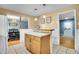Open kitchen with breakfast bar and view into dining area and front entry at 12821 W 60Th Ave, Arvada, CO 80004