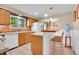 Traditional kitchen features tile floors, wood cabinets, and seating at the breakfast bar at 12821 W 60Th Ave, Arvada, CO 80004