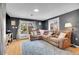 Living room featuring a large sofa, wood floors, bright windows, and sliding glass door with backyard view at 12821 W 60Th Ave, Arvada, CO 80004