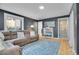 Living room showcasing a large sofa, wood floors, bright windows, and bookshelf at 12821 W 60Th Ave, Arvada, CO 80004