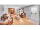 Open-concept living room with hardwood floors, a brick fireplace, and stylish furnishings at 12821 W 60Th Ave, Arvada, CO 80004